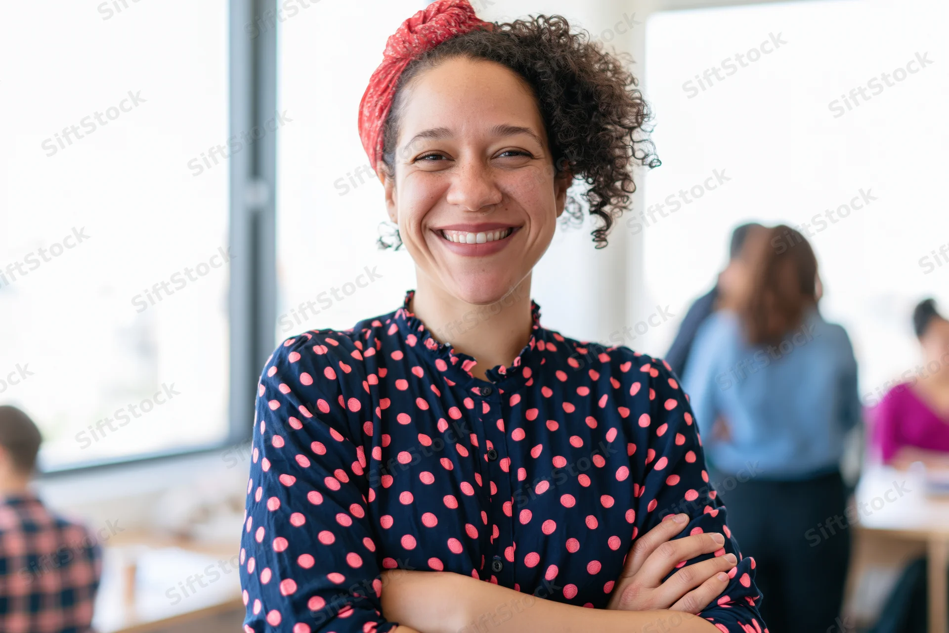 Woman smiling with arms crossed in office setting