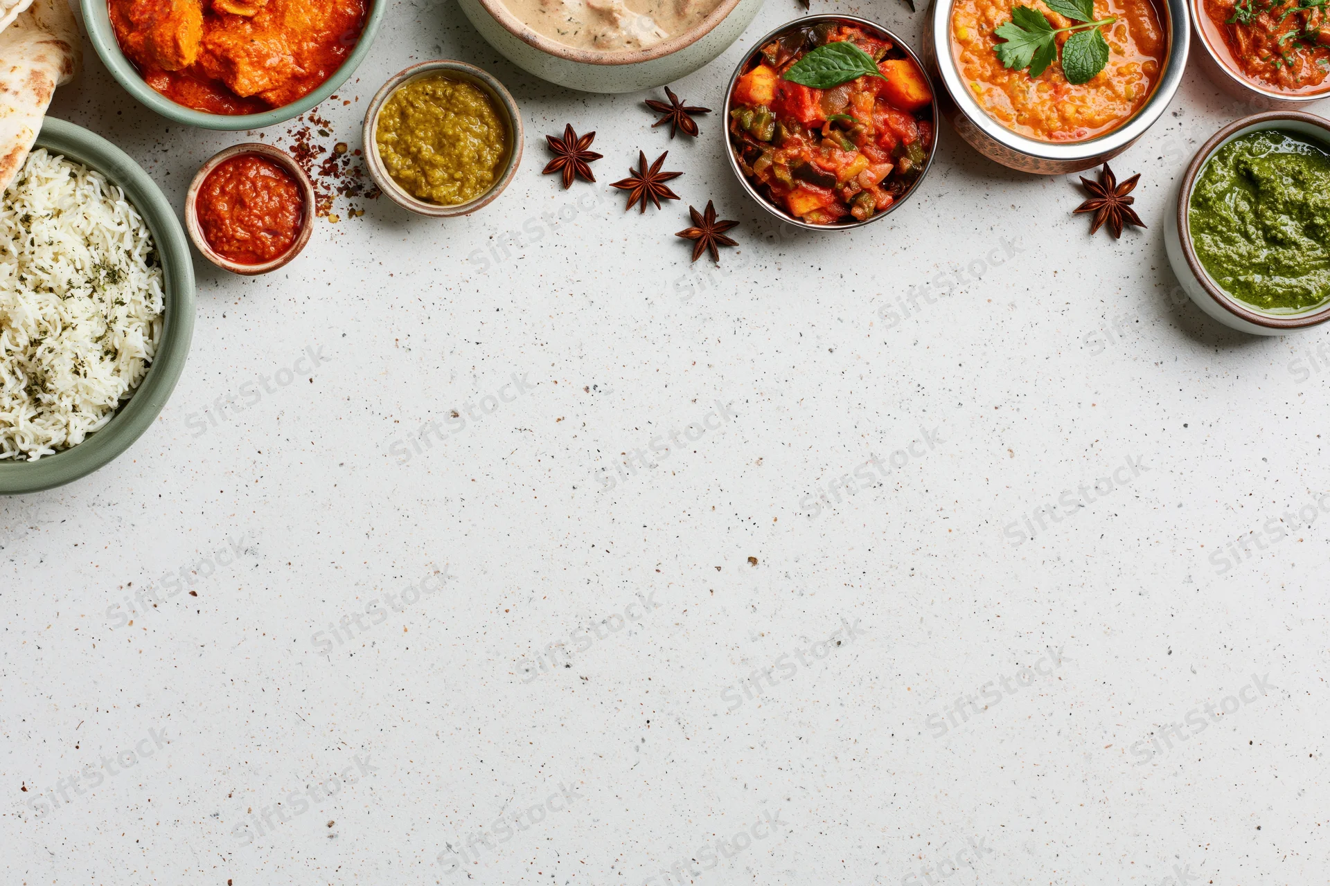 Assorted indian dishes arranged in a flat lay on a white surface with copyspace
