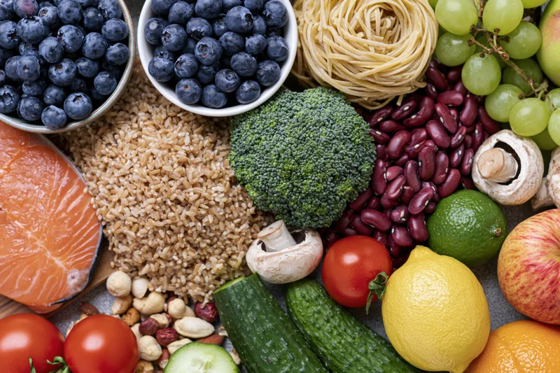Overhead flat lay of fresh whole foods densely arranged on a surface
