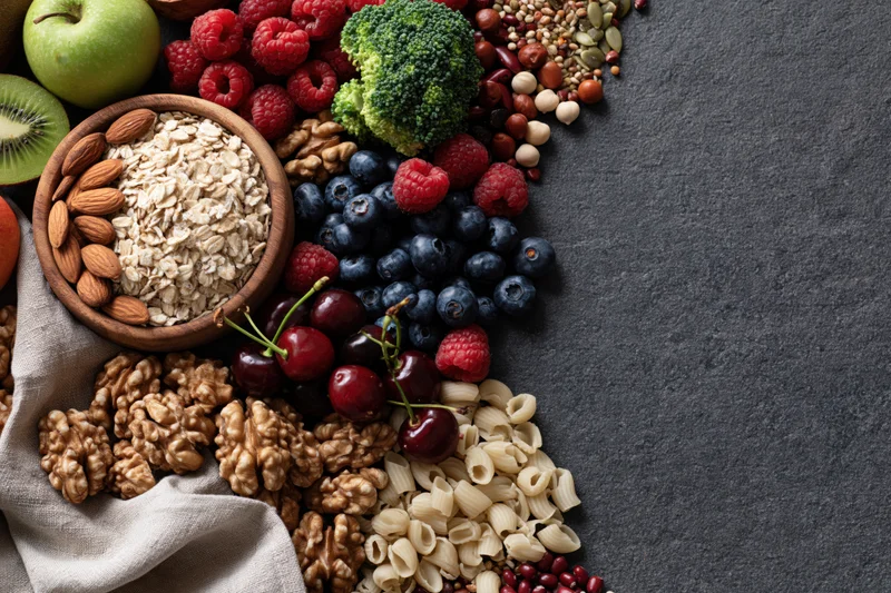 Mixed healthy foods arranged in flat lay on dark surface with copyspace