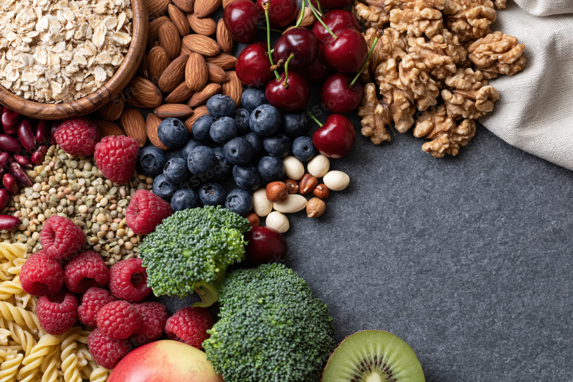 Mixed healthy foods arranged in a flat lay on dark surface with copyspace