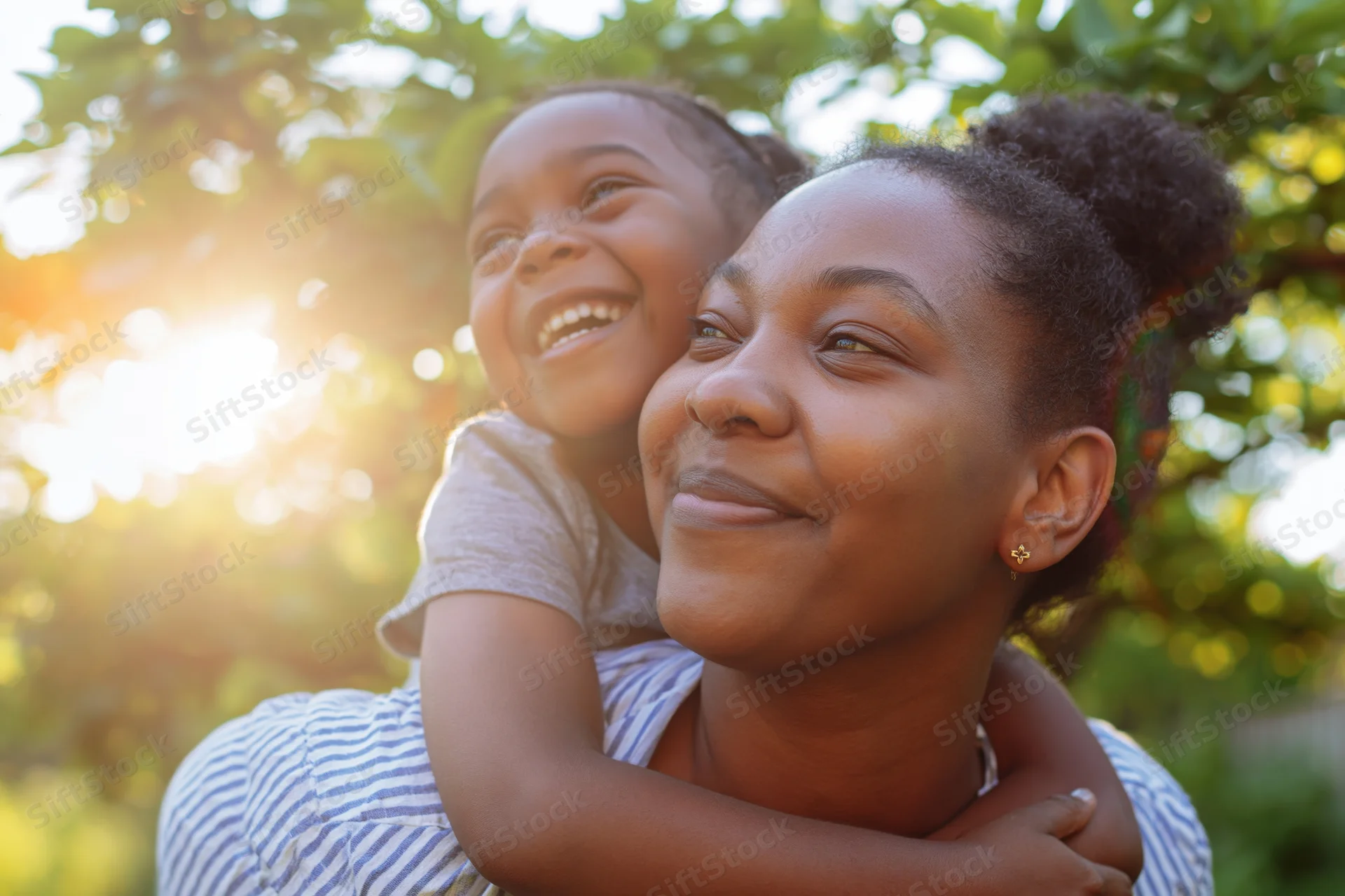 Mother giving daughter a piggyback ride outdoors in sunlight