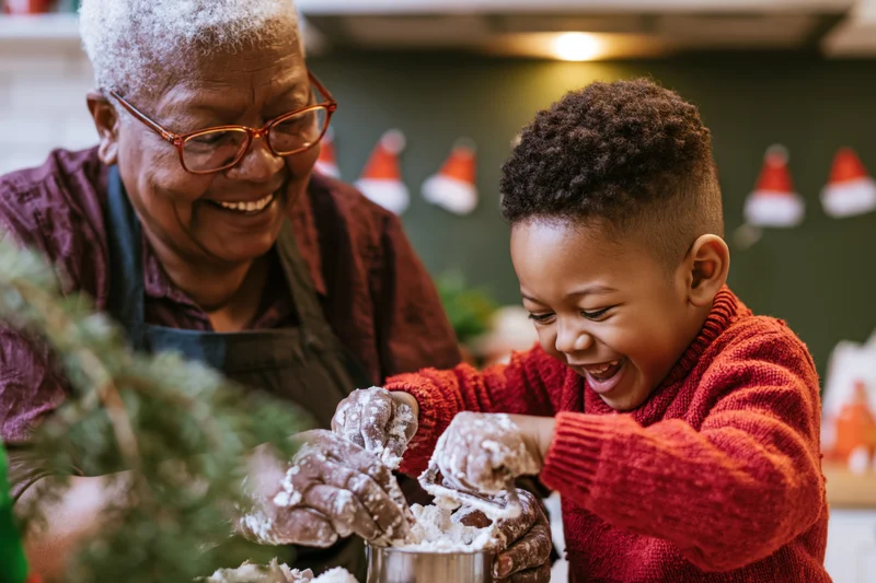 Grandmother and grandson baking together in a festive kitchen