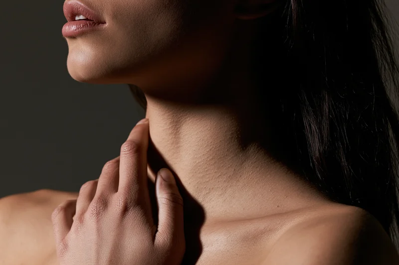 Woman touching her neck in profile closeup with soft lighting