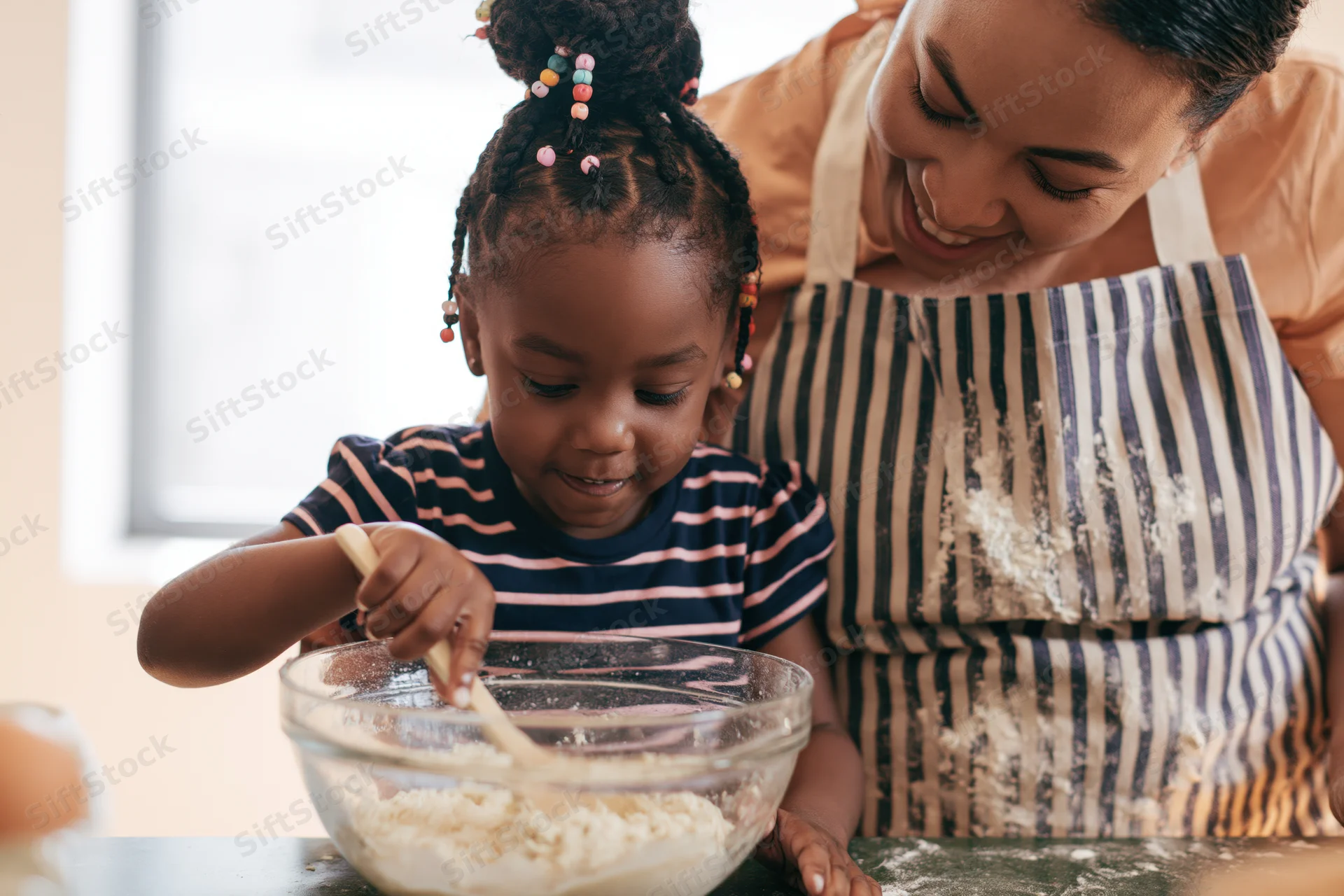 Mother and daughter baking together at kitchen counter