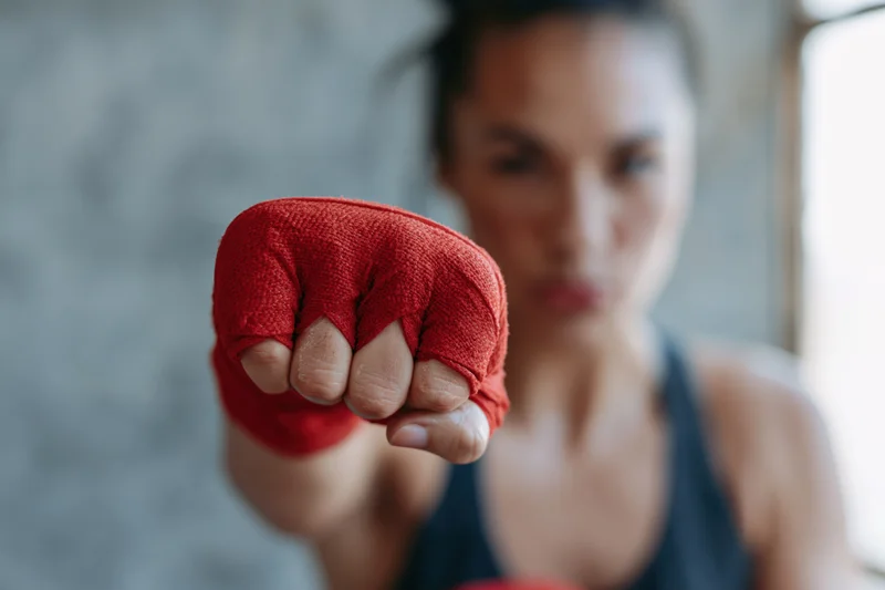 Woman boxer throwing a straight punch toward the camera in a gym
