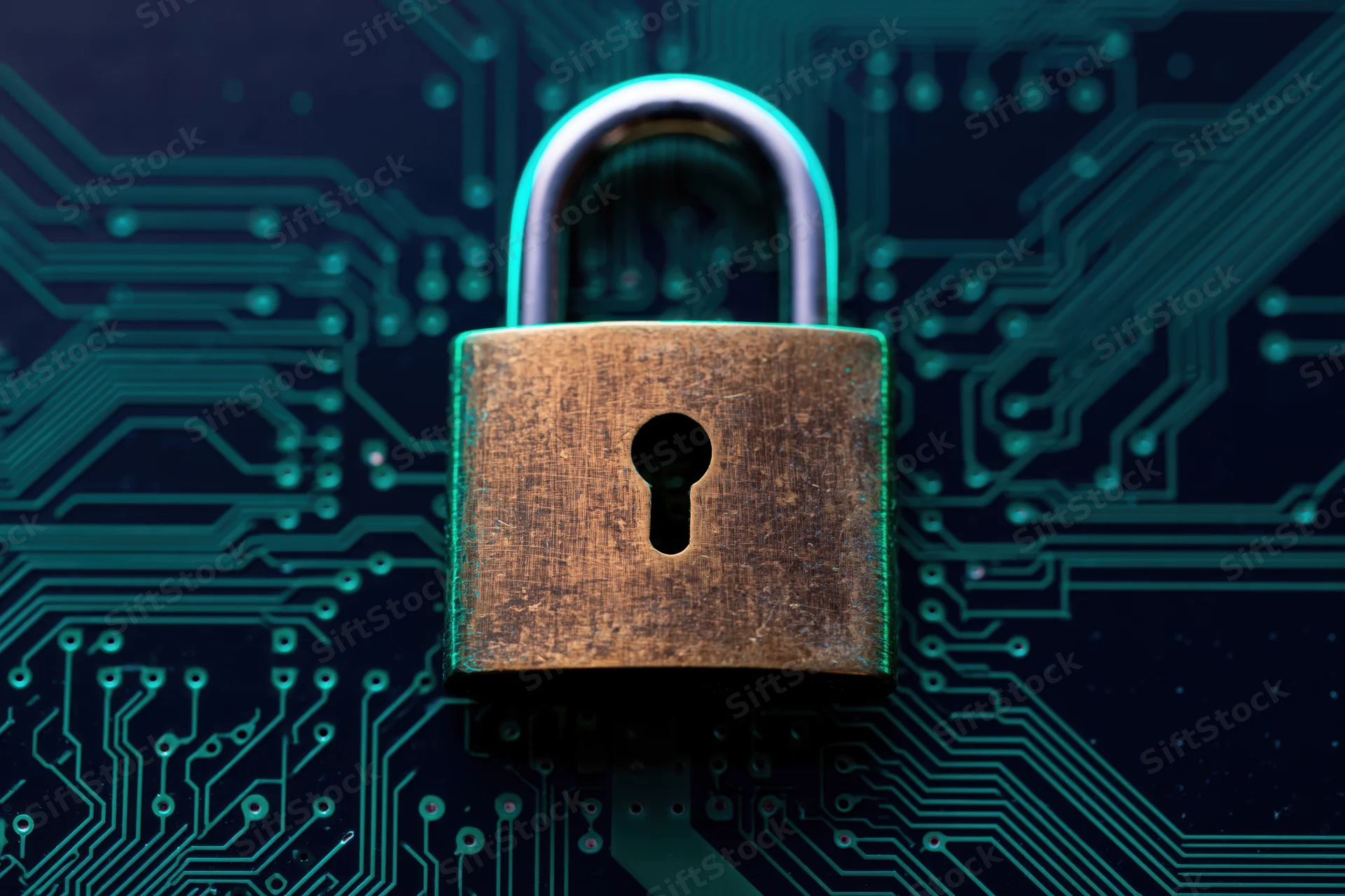 Brass padlock centered on dark circuit board with glowing teal traces