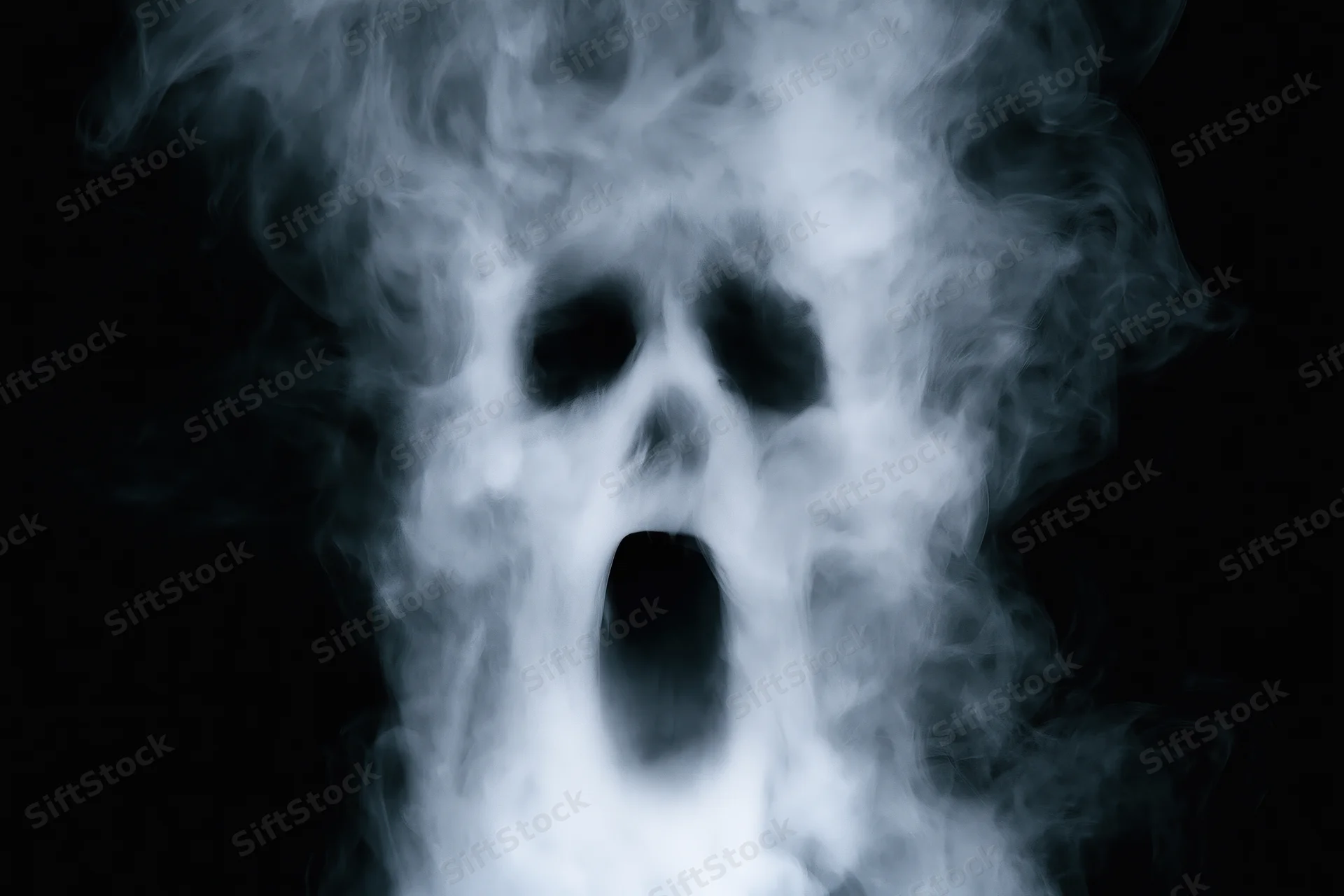 Ghostly skull formed from swirling smoke against black background