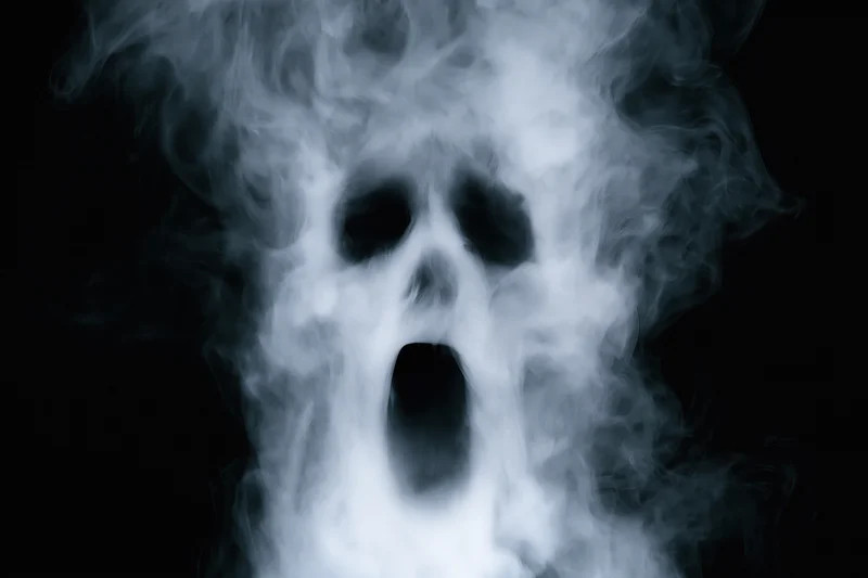 Ghostly skull formed from swirling smoke against black background