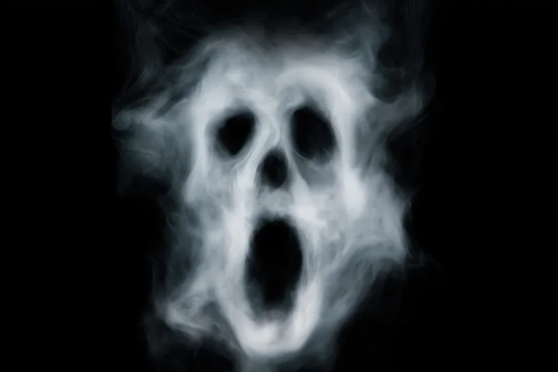Ghostly skull formed from swirling smoke against black background
