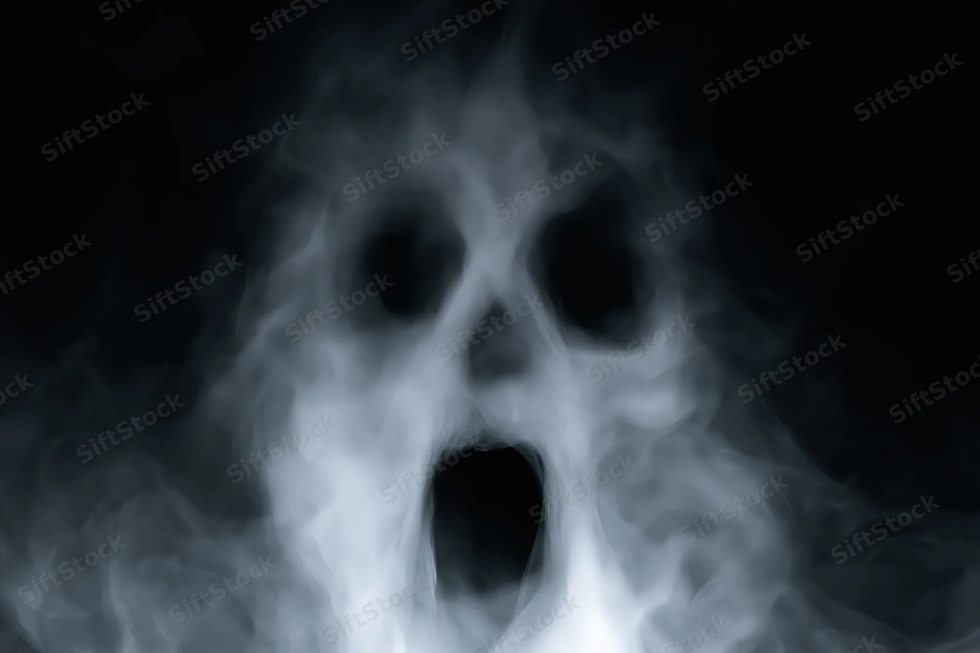 Ghostly face formed from swirling smoke against a dark background