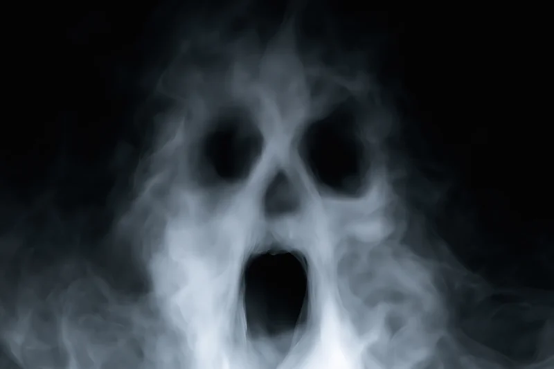 Ghostly face formed from swirling smoke against a dark background
