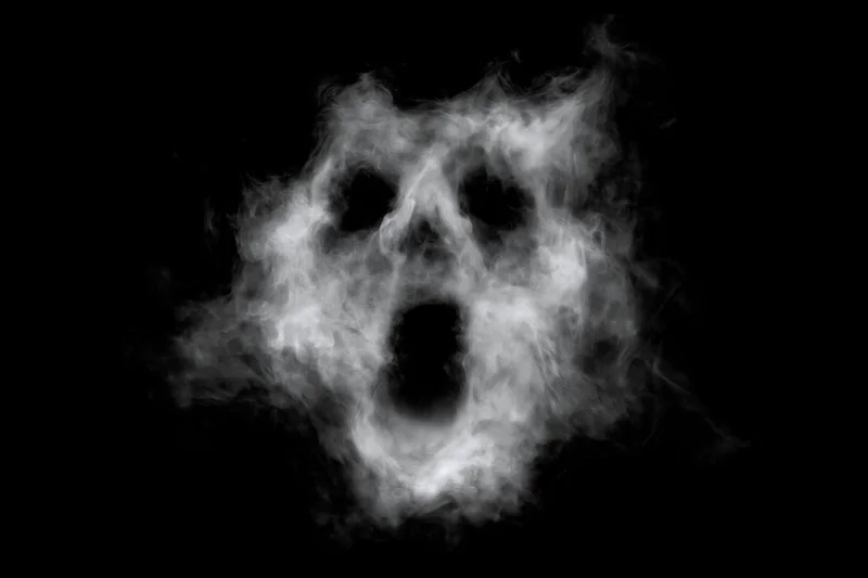 Ghostly face formed from swirling smoke against black background