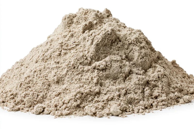 Mound of dry construction sand piled on a flat white surface