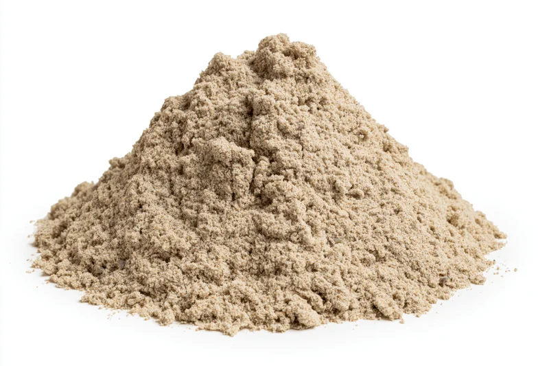Mound of dry construction sand on a white surface