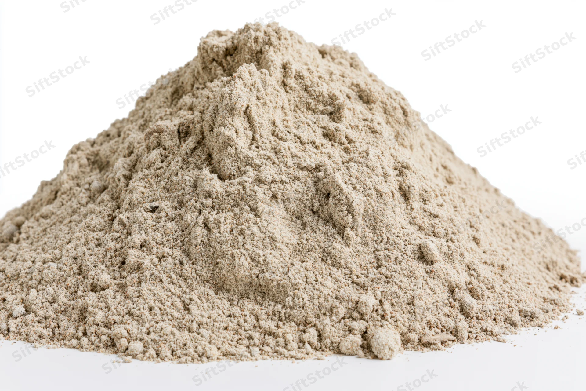 Mound of dry construction sand on a white surface