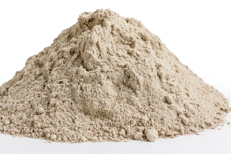 Mound of dry construction sand on a white surface