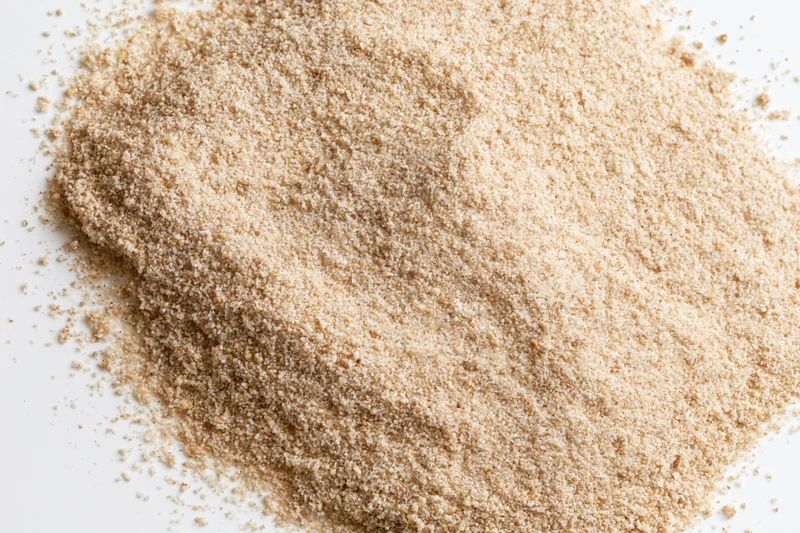Loose pile of fine dry sand scattered on a white surface