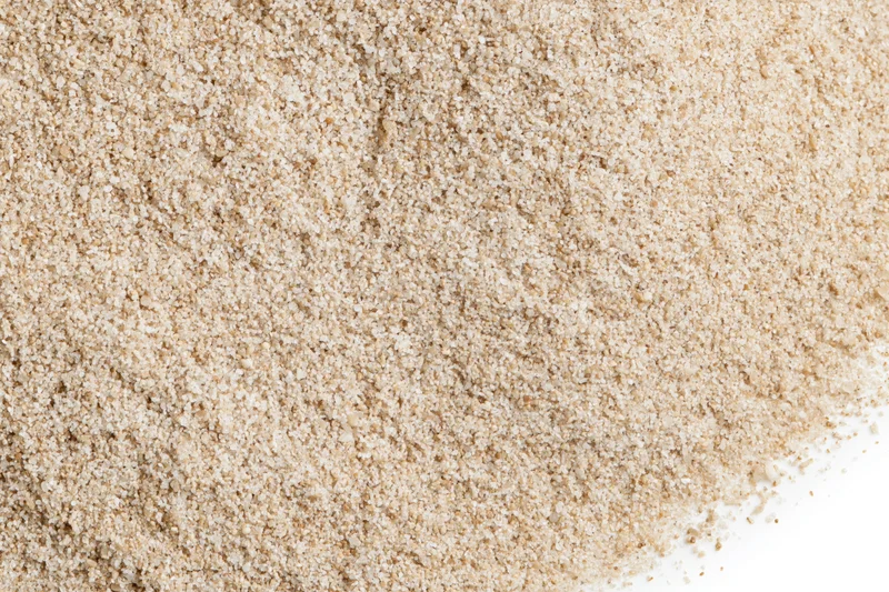 Loose pile of fine dry sand scattered flat on pure white background