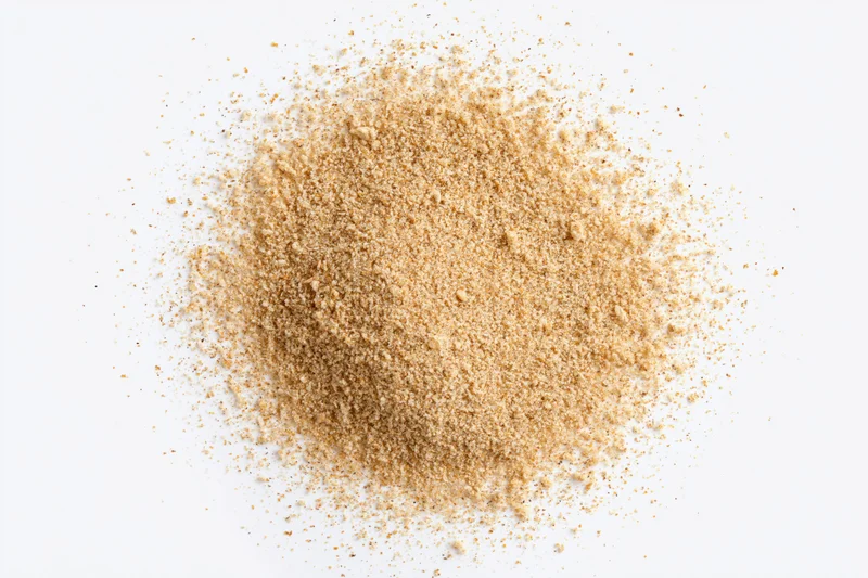 A pile of fine beige spice powder on a white surface