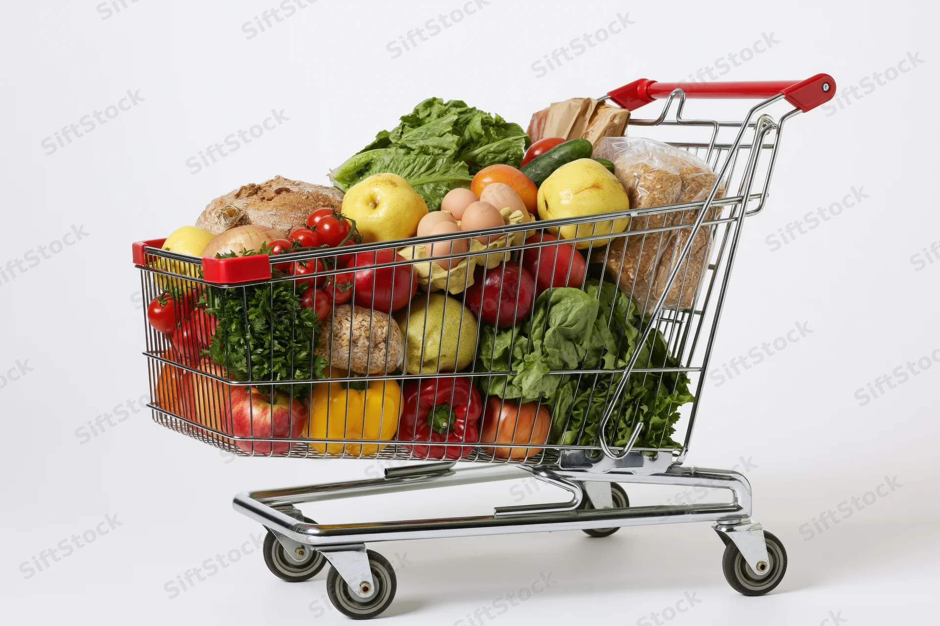 Metal shopping cart filled with fresh produce and groceries on white background