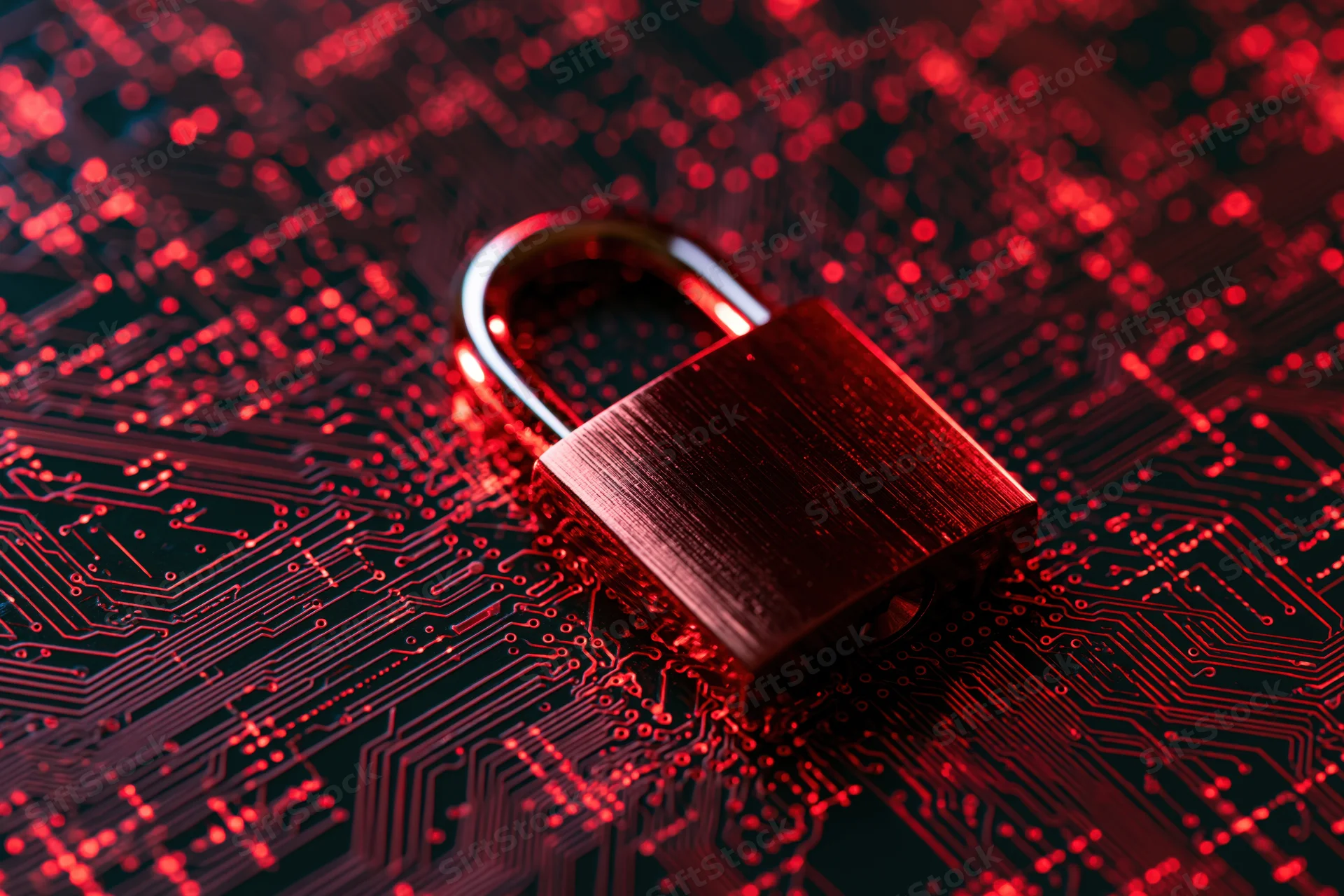 Metallic padlock glowing red on a circuit board surface