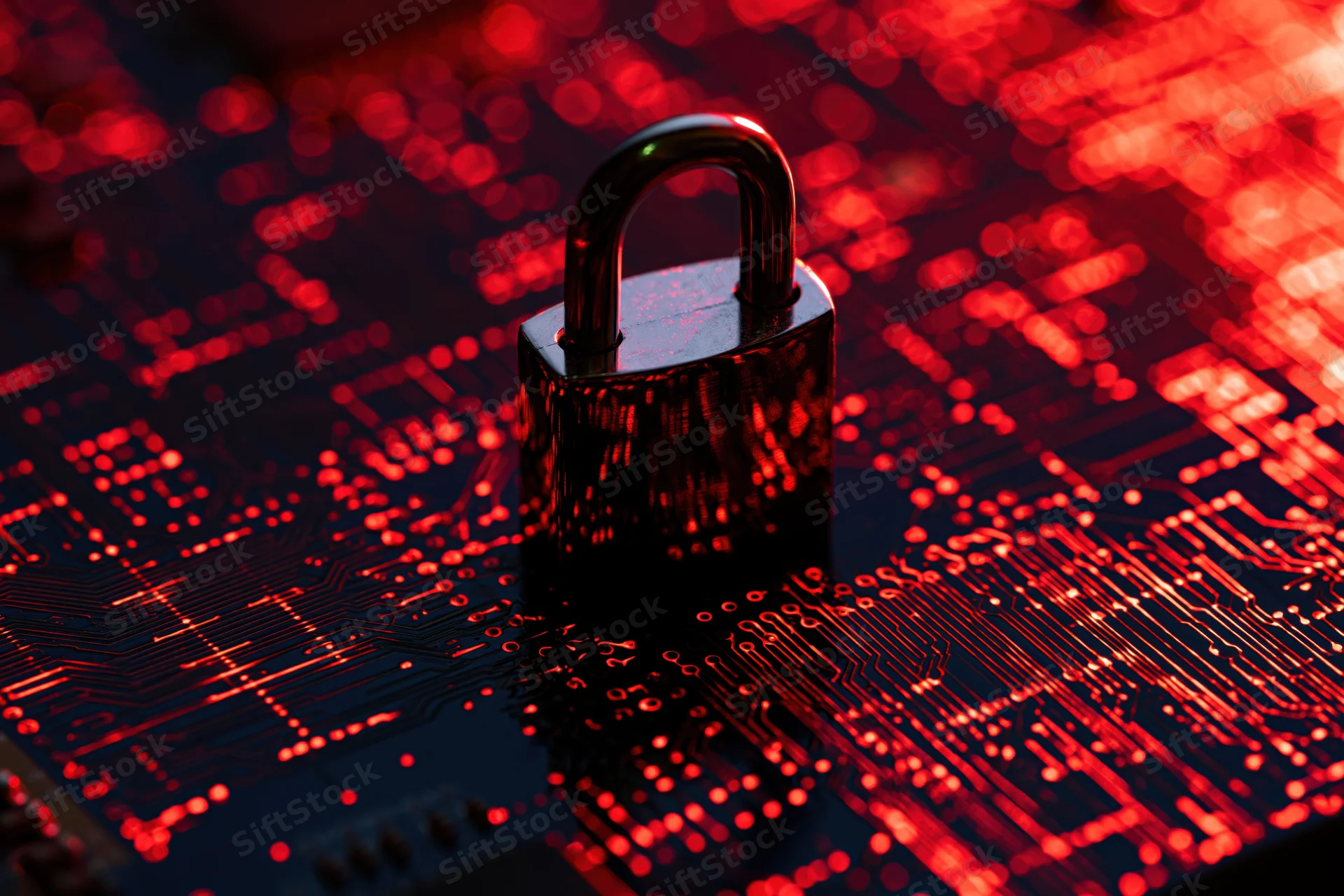 Metallic padlock glowing red on a circuit board surface