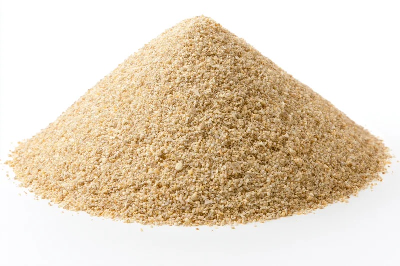 Conical pile of coarse dry sand on white background