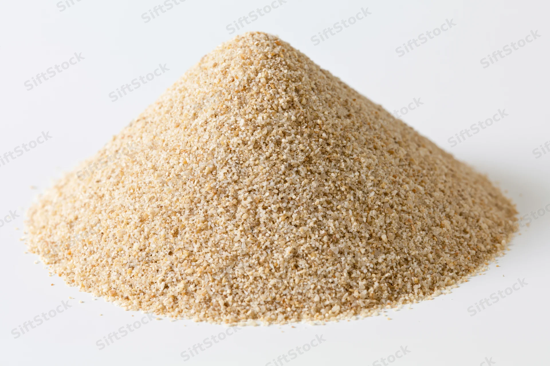 Conical pile of coarse dry sand on white background