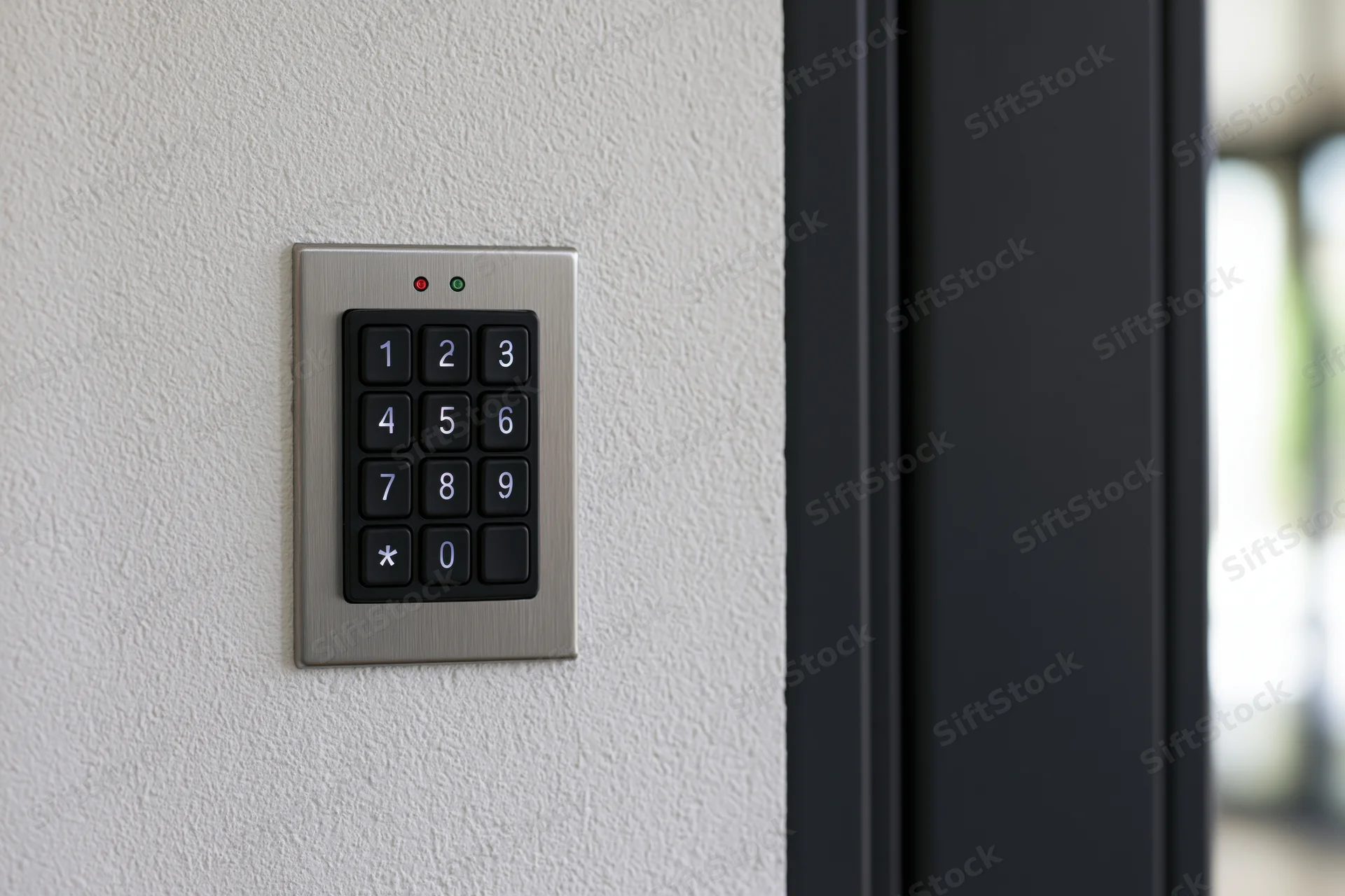Numeric keypad access control panel mounted on white textured wall beside dark doorframe