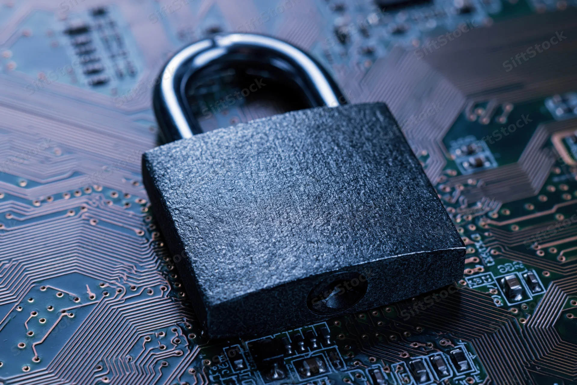 Metal padlock resting on a printed circuit board