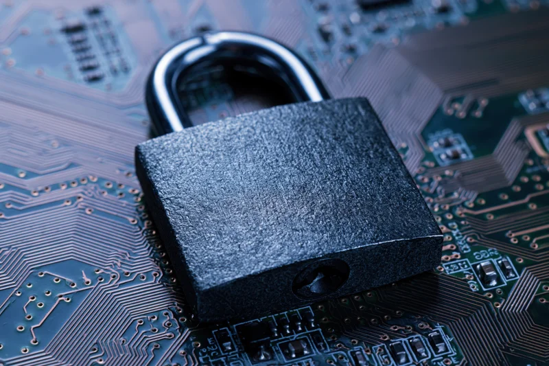 Metal padlock resting on a printed circuit board