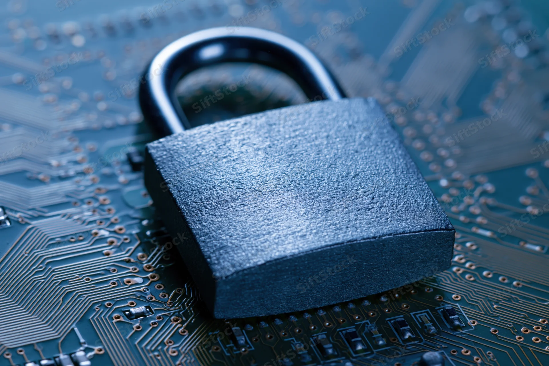 Metal padlock resting on a printed circuit board