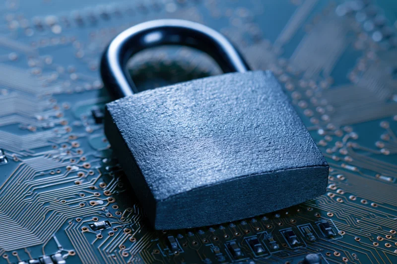 Metal padlock resting on a printed circuit board