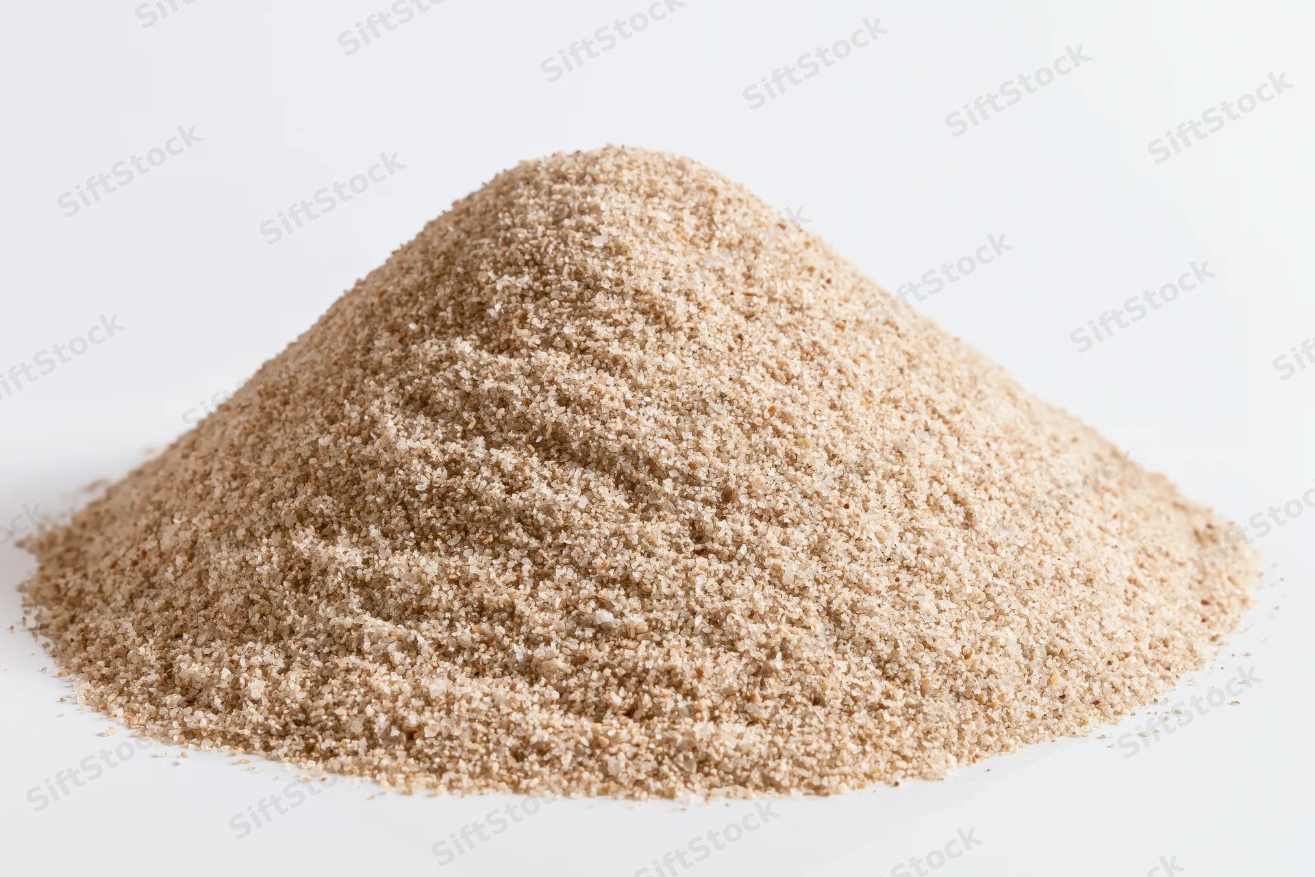 A small pile of dry fine-grain sand on a flat white surface