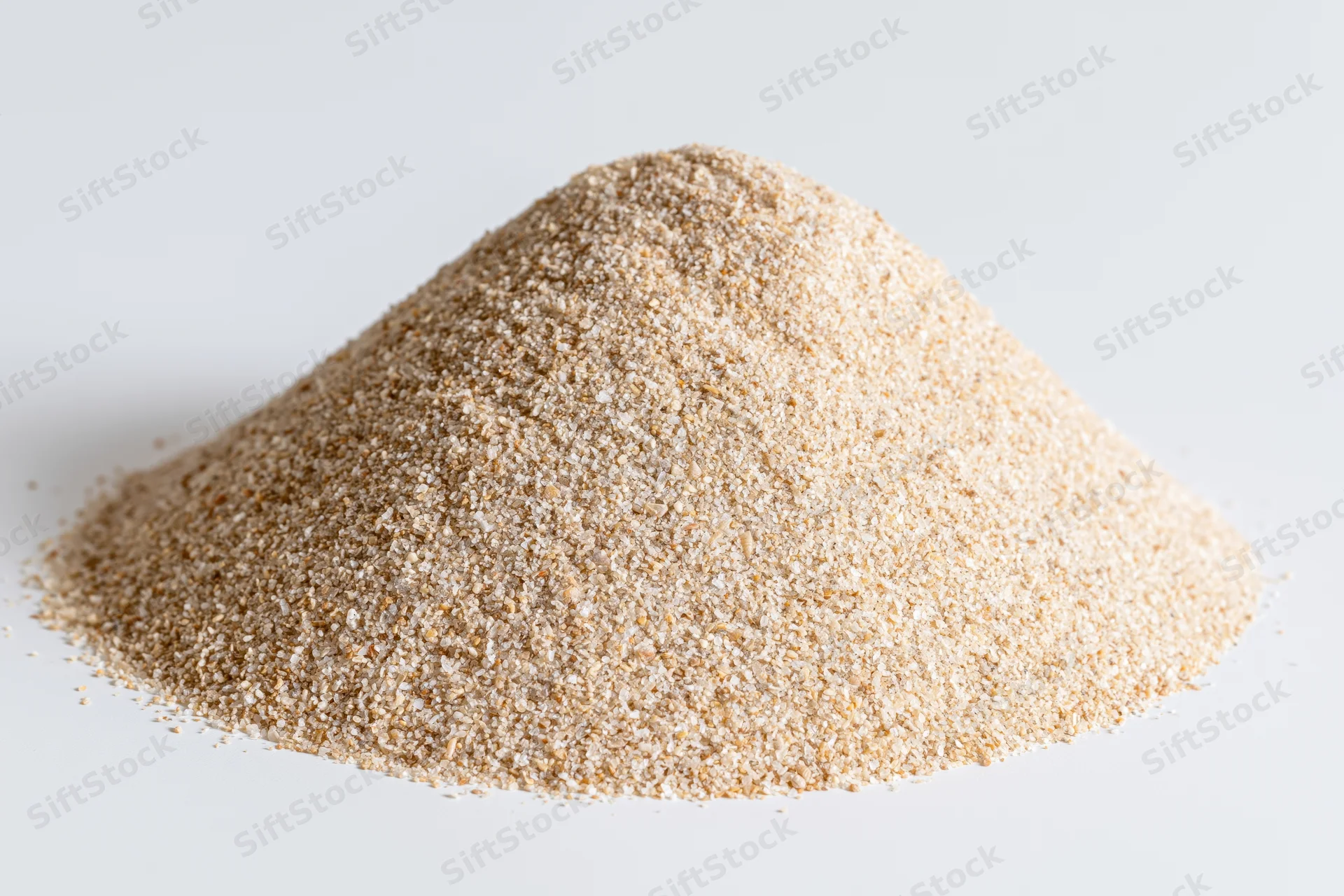 A pile of fine-grain sand on a white background