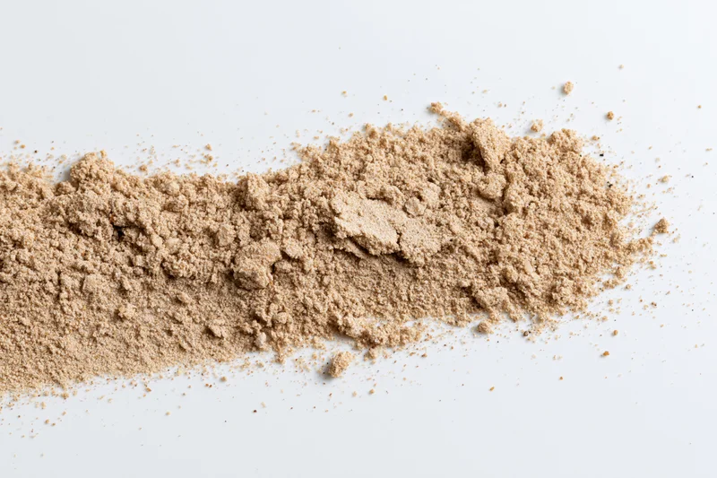 Fine dry sand scattered in a low horizontal pile on white background