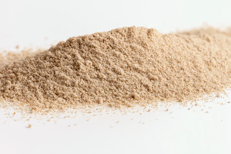 A pile of fine dry sand scattered on a white surface