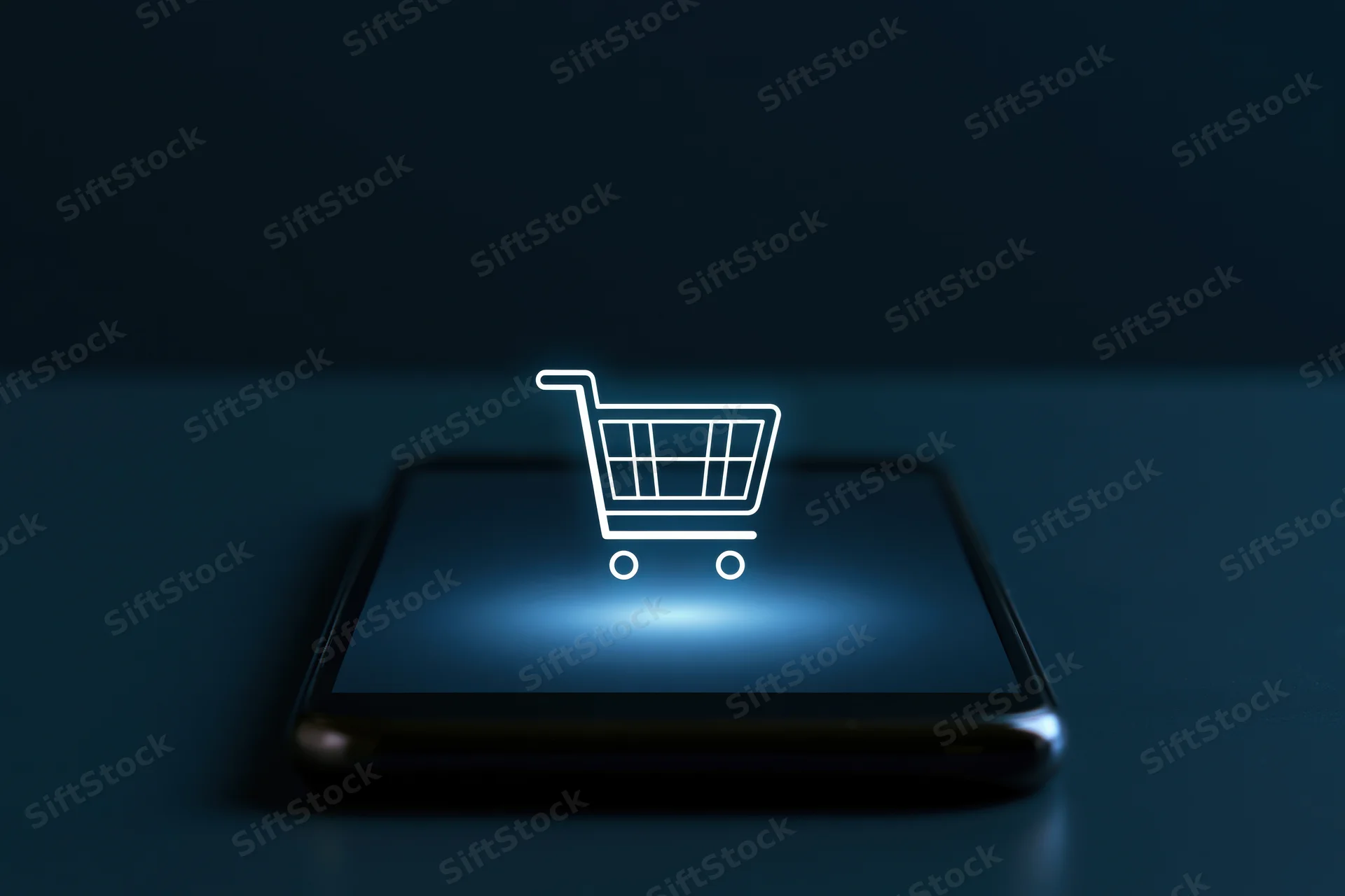 Smartphone with glowing shopping cart icon on dark surface