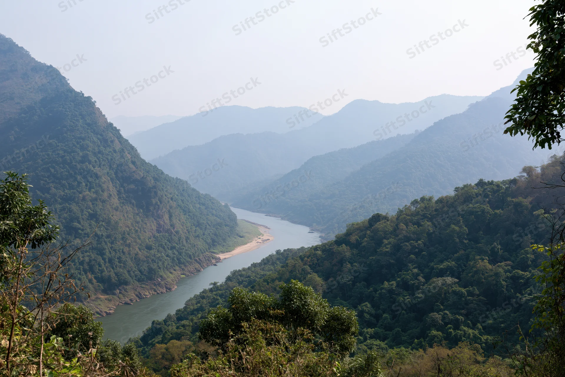 Wide river winding through deep forested mountain valley