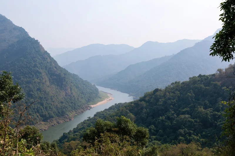 Wide river winding through deep forested mountain valley