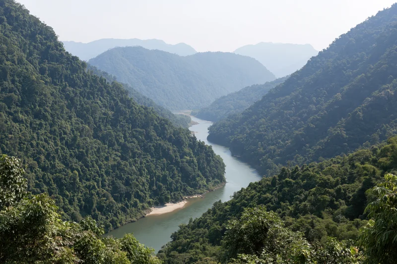 Wide river winding through deep forested mountain valley