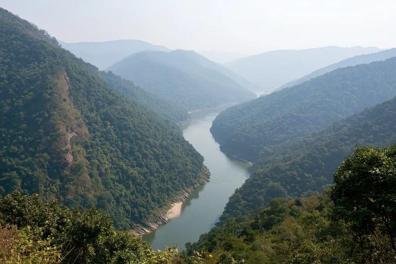 Wide river winding through deep forested mountain valley