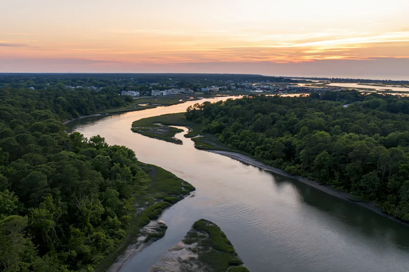 Aerial drone view of a winding tidal marsh estuary at sunset
