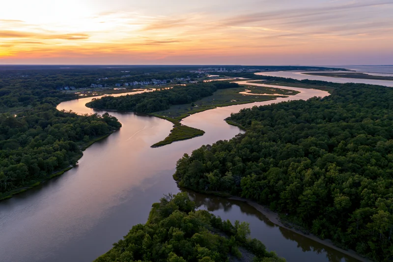Aerial drone view of a winding tidal marsh estuary at sunset