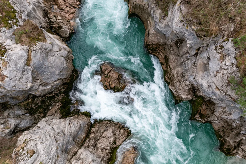 Turquoise river flowing through narrow rocky gorge from above