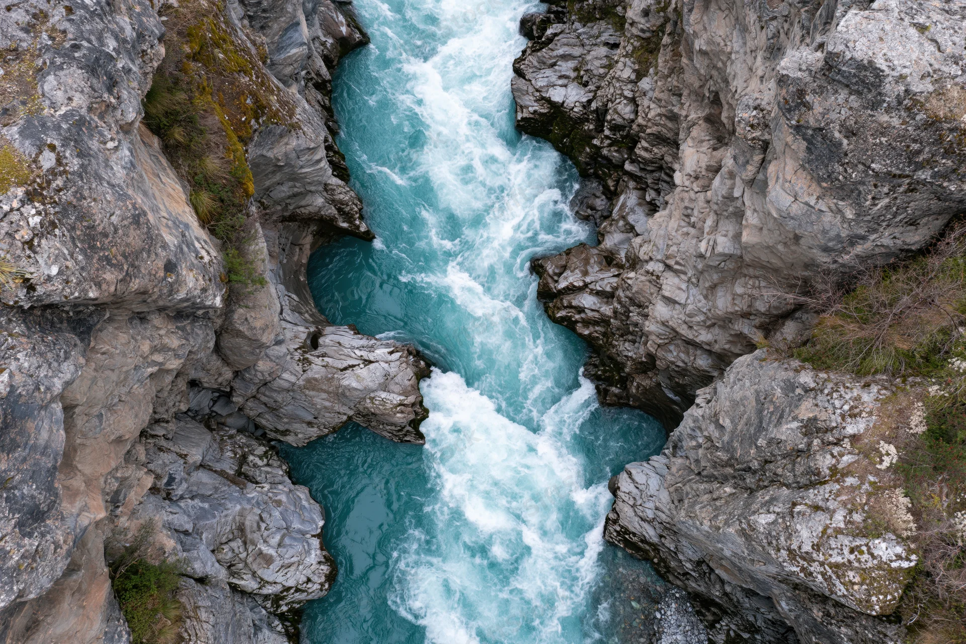 Turquoise river flowing through narrow rocky gorge from above