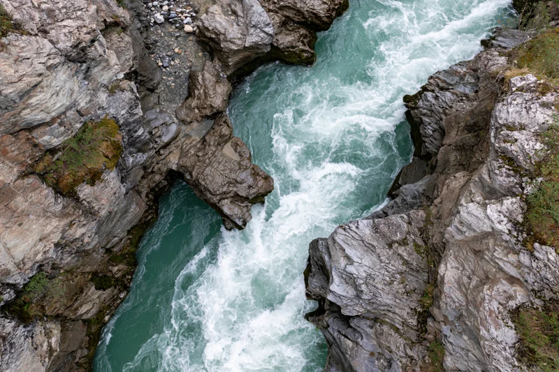 Turquoise river rushing through narrow rocky gorge from above