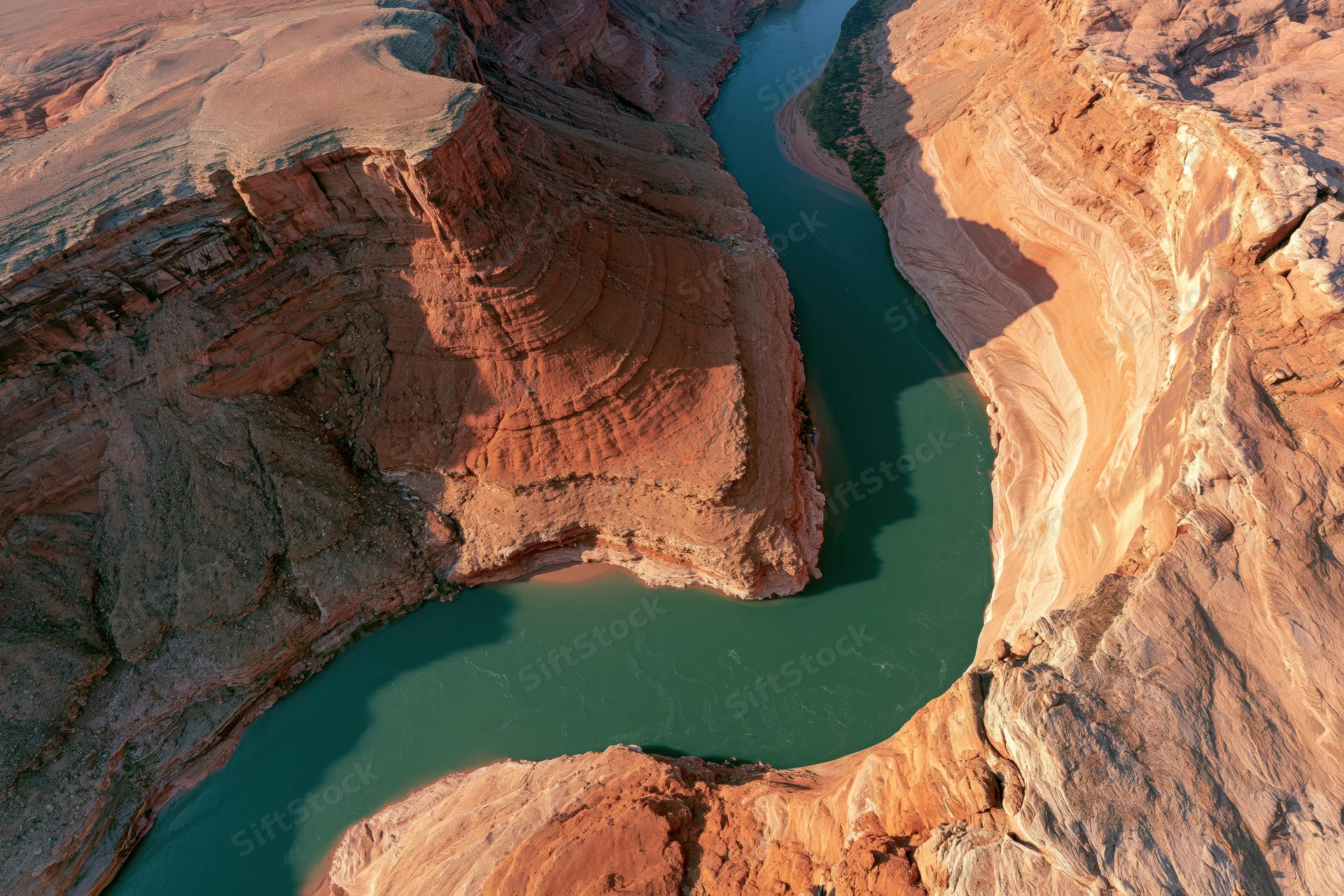 Aerial view of a winding river cutting through a deep desert canyon