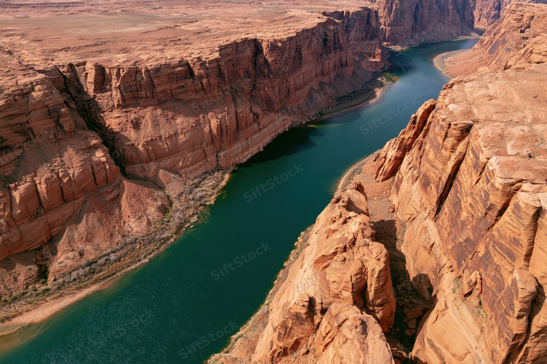 Aerial view of a winding river cutting through a deep desert canyon